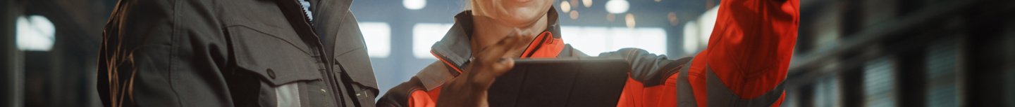 Surveying woman points to distant object while man looks at clipboard